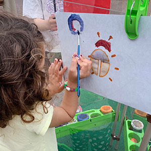 ett barn målar en nyckelpiga på ett staffli