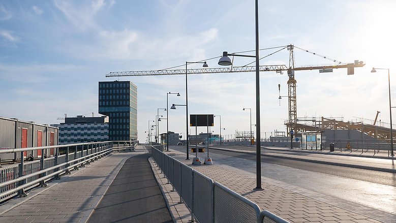 Veddestabron har varit öppen för trafik sedan sommaren 2022. Till höger kan du se den kommande stationsbyggnaden och den 50 meter hög kranen.