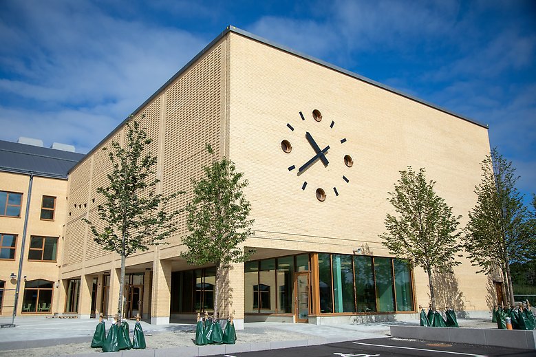 Bild på Ålstaskolans fasad med klocka