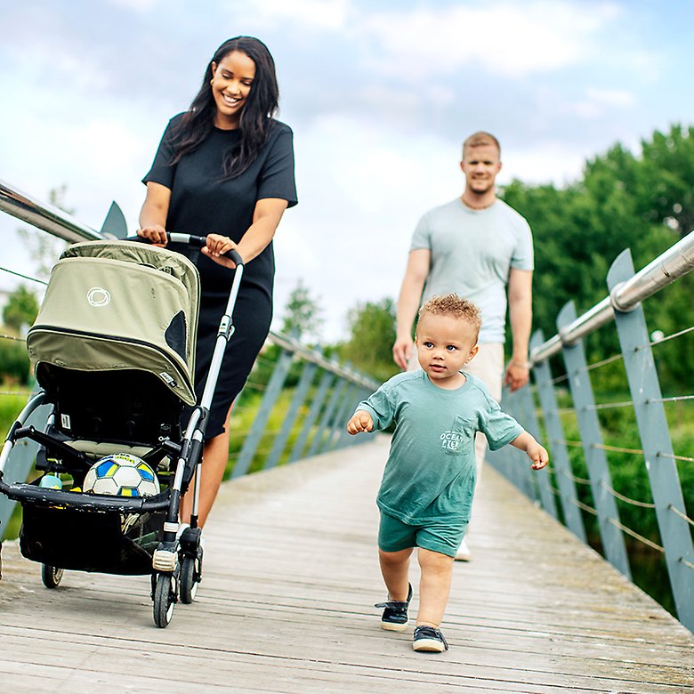 Familj med ett barn och en person som går men barnvagn.